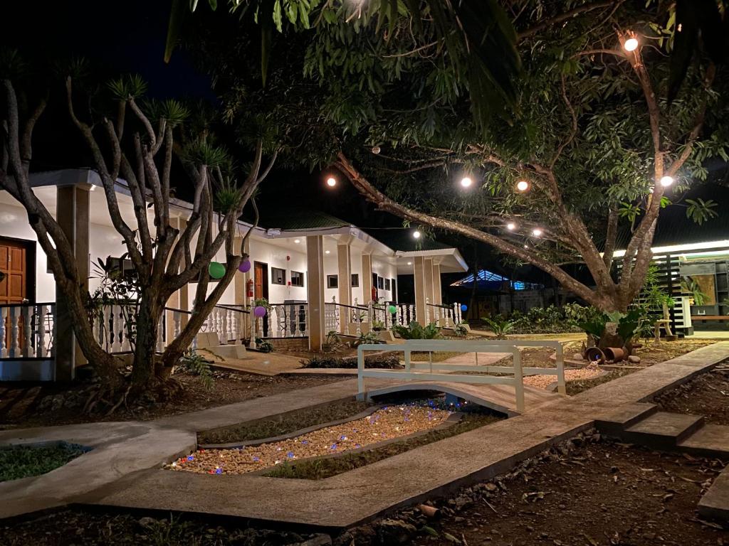 un banco de parque frente a un edificio por la noche en LS Garden Villa, en Puerto Princesa City