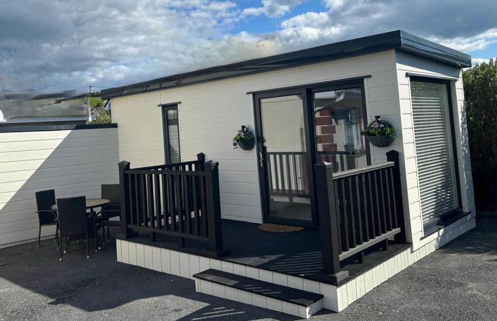 a tiny house with a deck and a table at The Little Nest @ Slaney House in Lahinch