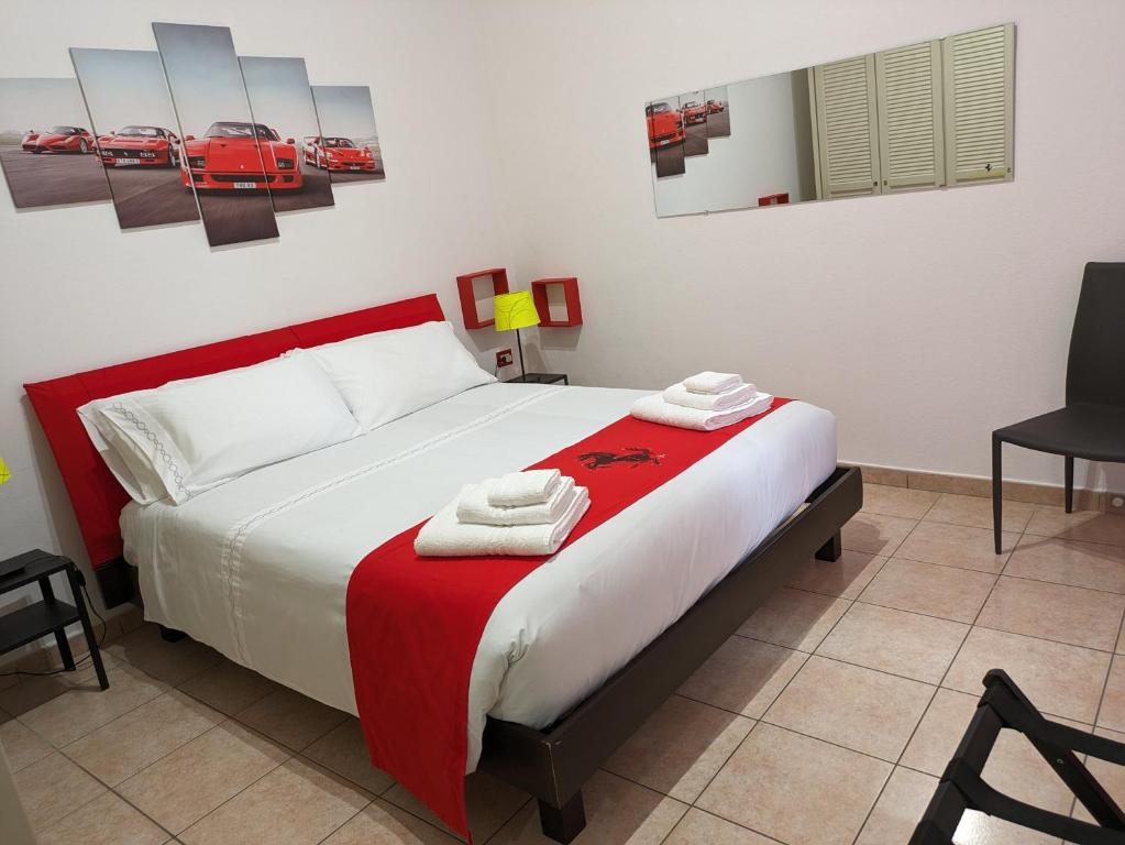 una camera con un letto con una coperta rossa e bianca di Il Cavallino, sul lago Ceresio a Brusimpiano