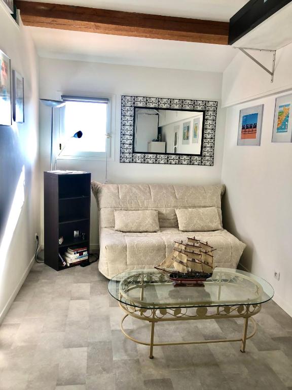 un salon avec un canapé et une table en verre dans l'établissement Charmant Studio Indépendant Le Broc avec parking privé, à Le Broc