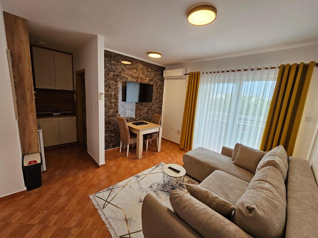 ein Wohnzimmer mit einem Sofa und einem Tisch in der Unterkunft Dom M Apartments in Budva