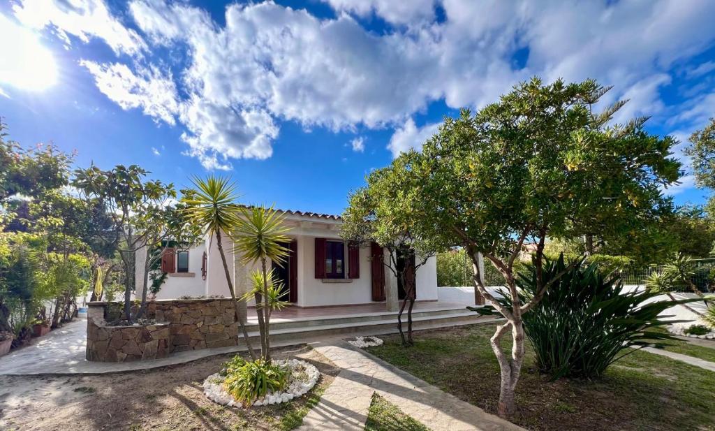 a white house with trees in front of it at Villa Peru in Tanaunella