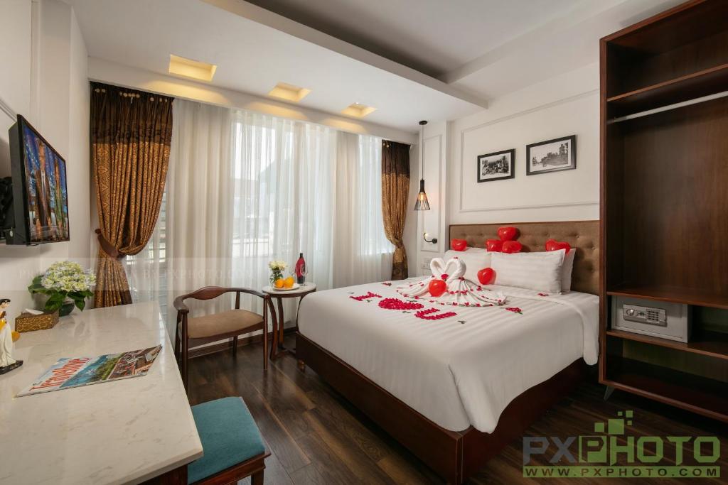 Victory Legend Hotel - In Hanoi Central في هانوي: غرفة فندق بسرير كبير عليها ديكورات حمراء