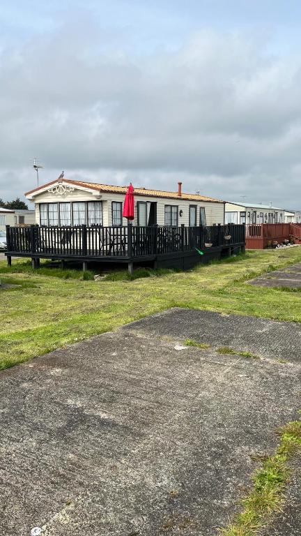 a white building with a red item on it at Caravan home Clacton-On-Sea St Osyth in Saint Osyth