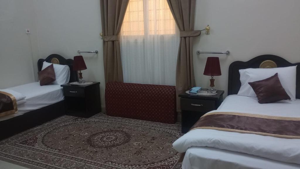 um quarto de hotel com duas camas e uma janela em العييري للشقق المفروشة االنعيريه 1 em Al Nairyah