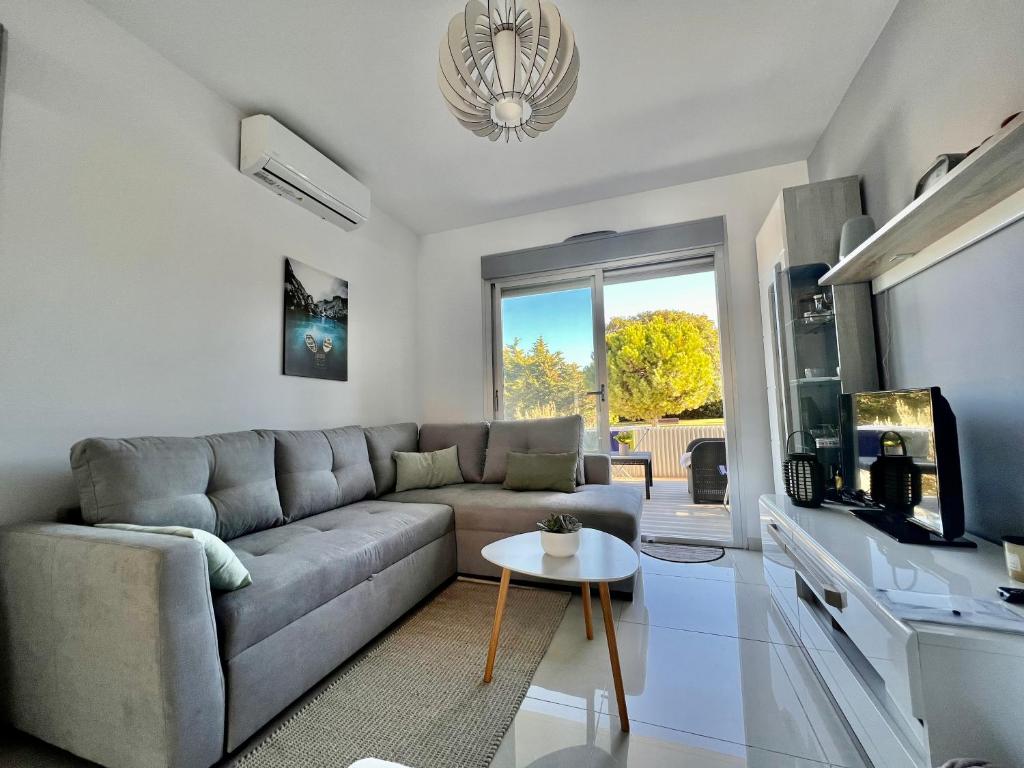 ein Wohnzimmer mit einem Sofa und einem Tisch in der Unterkunft Bungalow en Punta Prima 2 dormitorios y piscina in Torrevieja