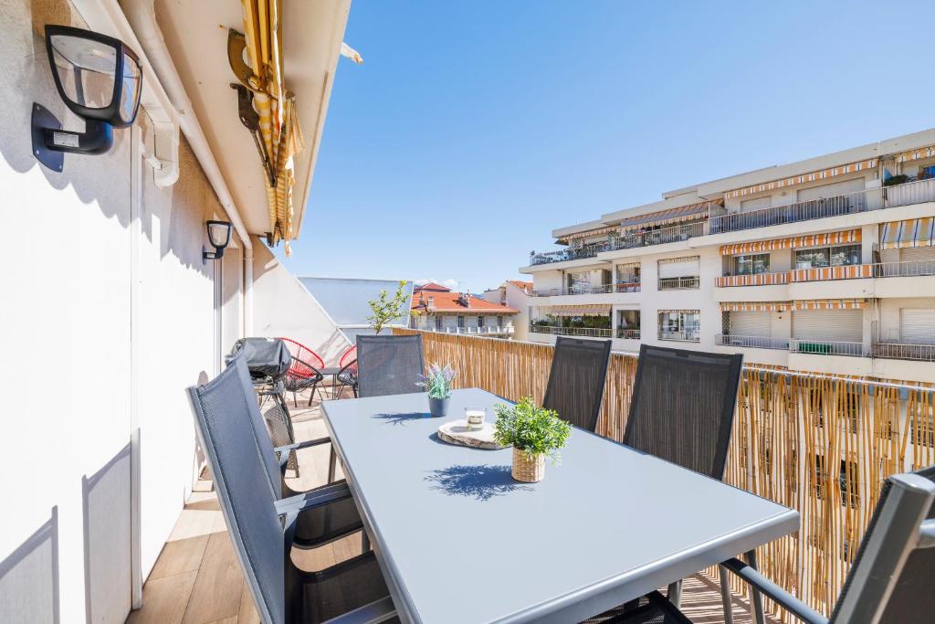 une table et des chaises sur le balcon d'un bâtiment dans l'établissement Le Hammam, à Nice