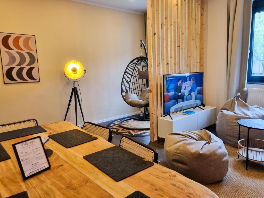 uma sala de estar com uma mesa e uma televisão em maremar - Design im Zentrum - Luxus Boxspringbetten - Arbeitsplätze & Highspeed WLAN - Balkon em Braunschweig