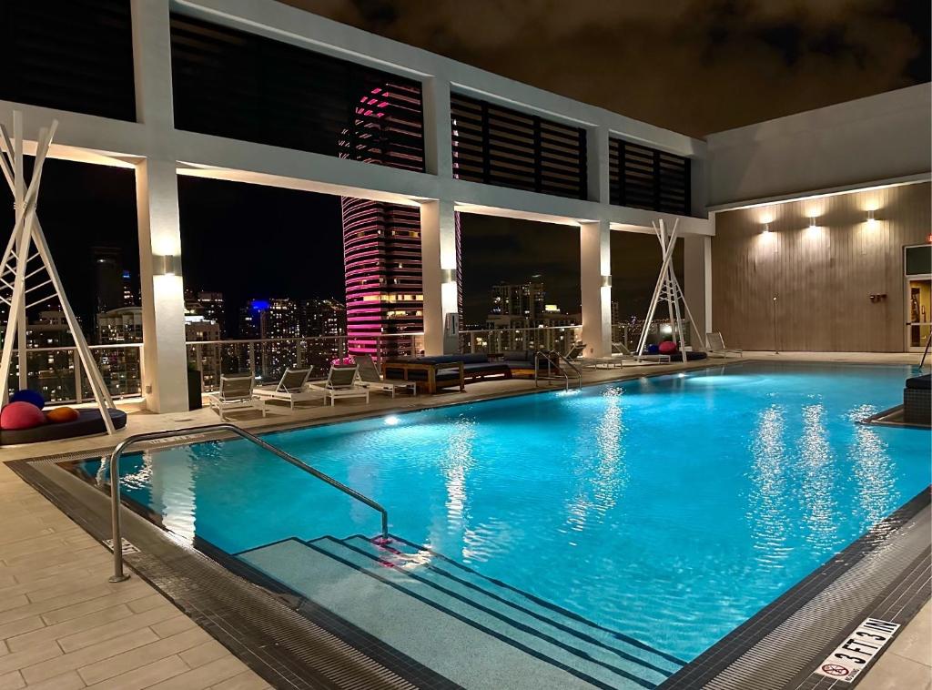 Luxe Loft Heart of Miami Brickell Downtown في ميامي: مسبح في الليل مع أفق المدينة