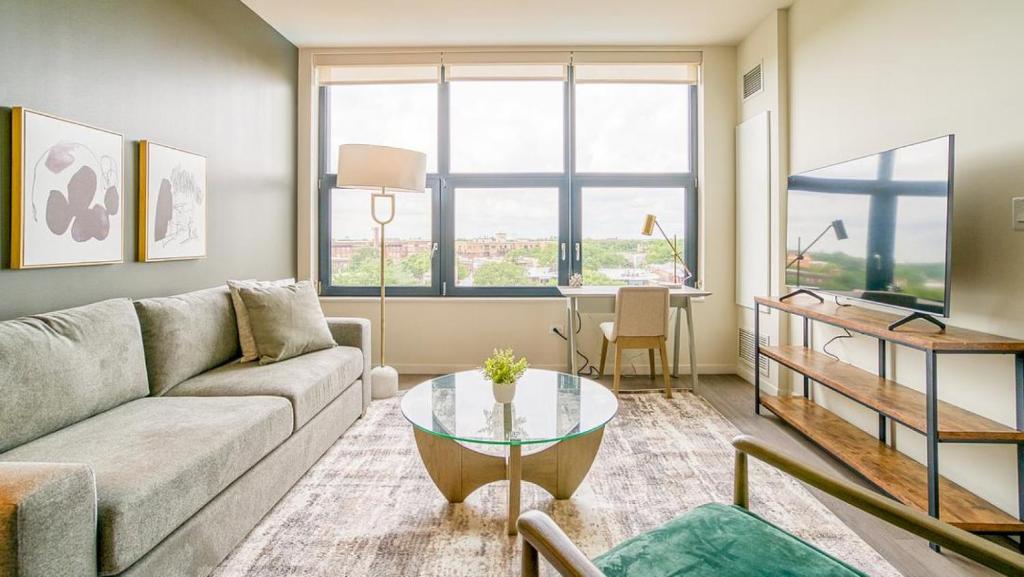 a living room with a couch and a table at Landing at Logan Apartments - 1 Bedroom in Logan Square in Chicago