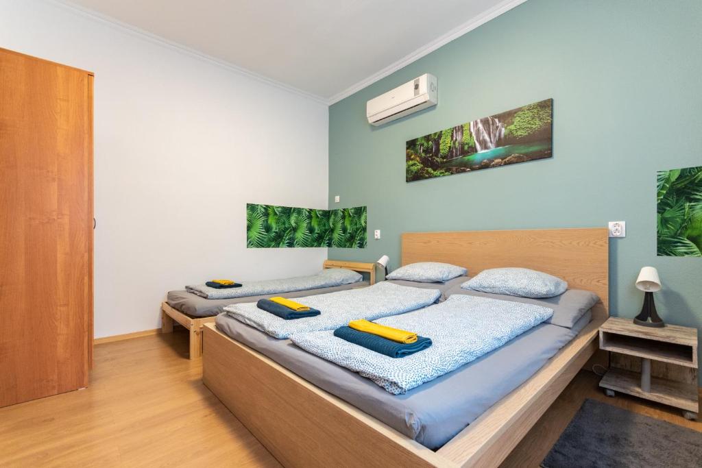 2 camas en una habitación con paredes azules en K52 Apartment Budapest en Budapest
