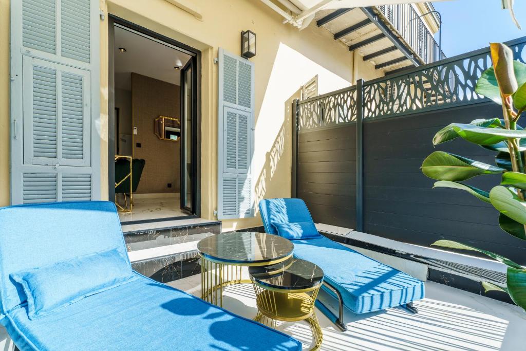 - un balcon avec deux chaises bleues et une table dans l'établissement Nice Renting - 4FRANCE - Luxury & Comfort Suite by the Sea & Terrace, à Nice
