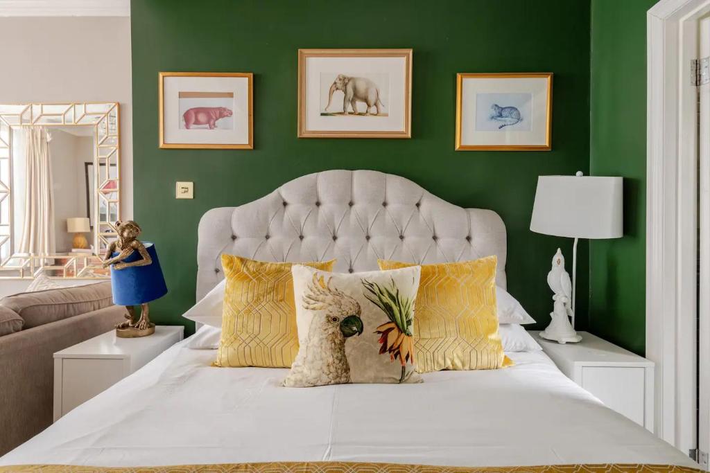a bedroom with a white bed with a green wall at Deco Studio: King bed, kitchenette, stylish & comfortable in Brighton & Hove