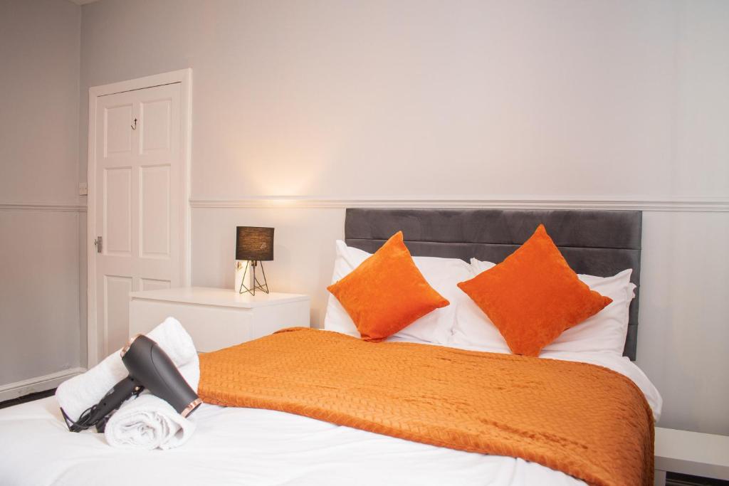 a bedroom with a bed with orange and white pillows at Stylish 1 Bedroom Flat Newcastle in Old Walker