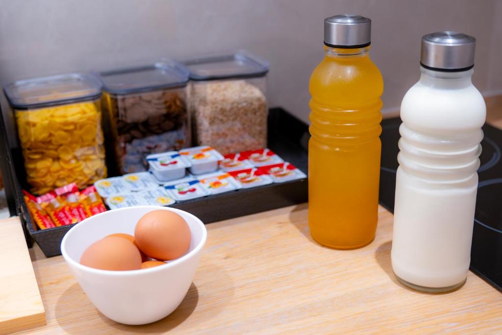 a table with a bowl of eggs and a bottle of milk at Nissos Apartments in Myrina