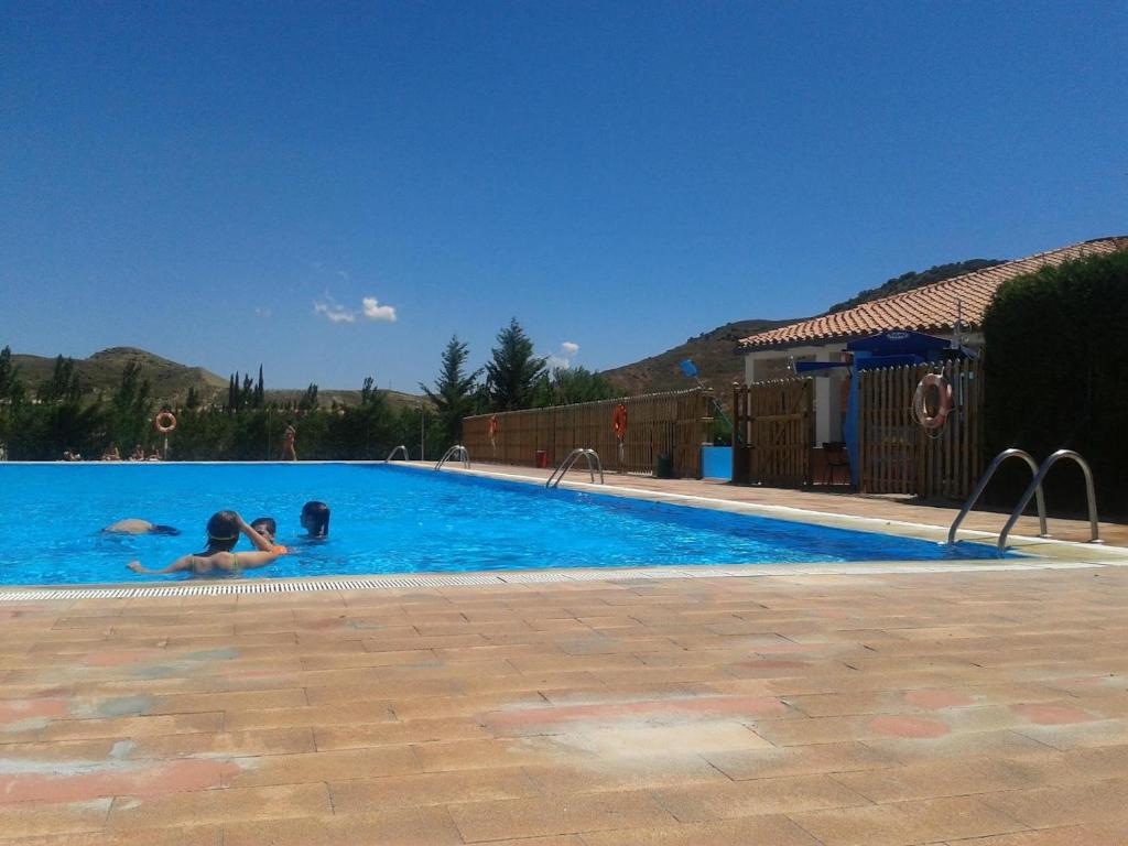 two people are swimming in a swimming pool at Villa Mirador in Manzanera