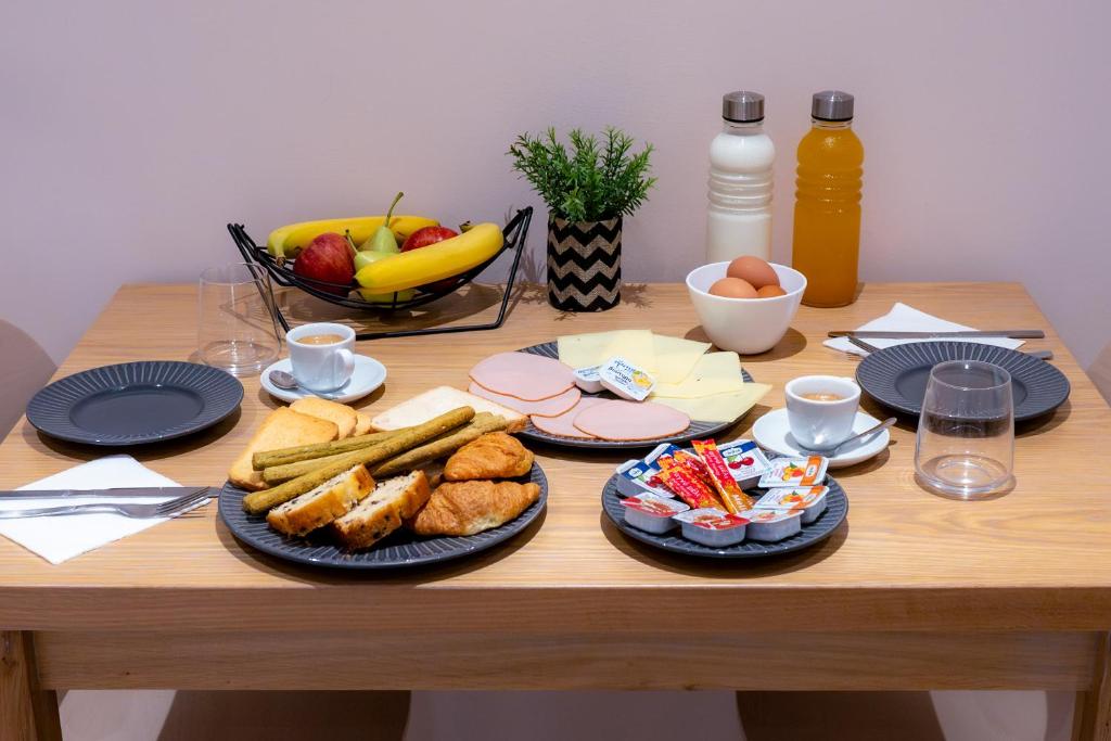 a table with plates of food and a bowl of fruit at Nissos Apartments in Myrina