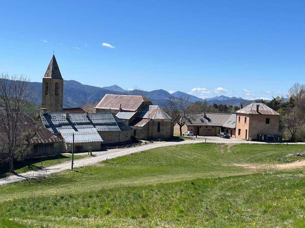 un vieux village avec une église et un champ vert dans l'établissement Six Duplex à la montagne POMPIERY, à Seyne