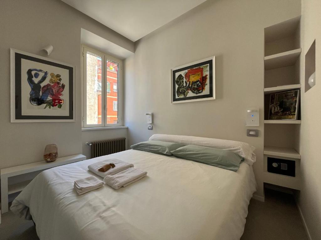 a bedroom with a white bed with towels on it at CARPE DIEM, Ponte Milvio, Olimpico, Farnesina in Rome