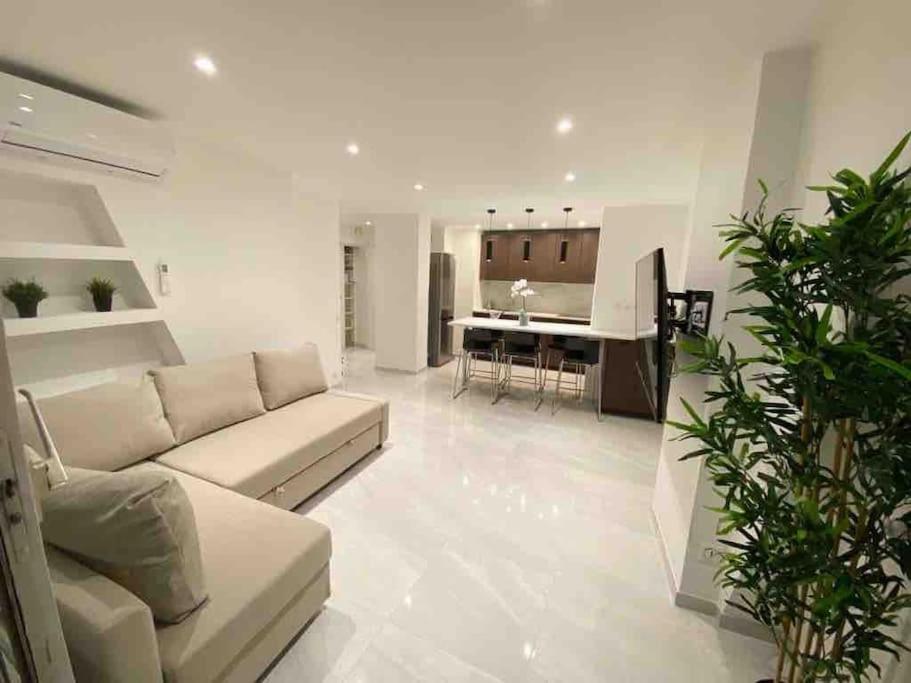 un salon avec un canapé et une cuisine dans l'établissement Carré Or - Standing Hyper centre plage 2 min, à Saint-Raphaël