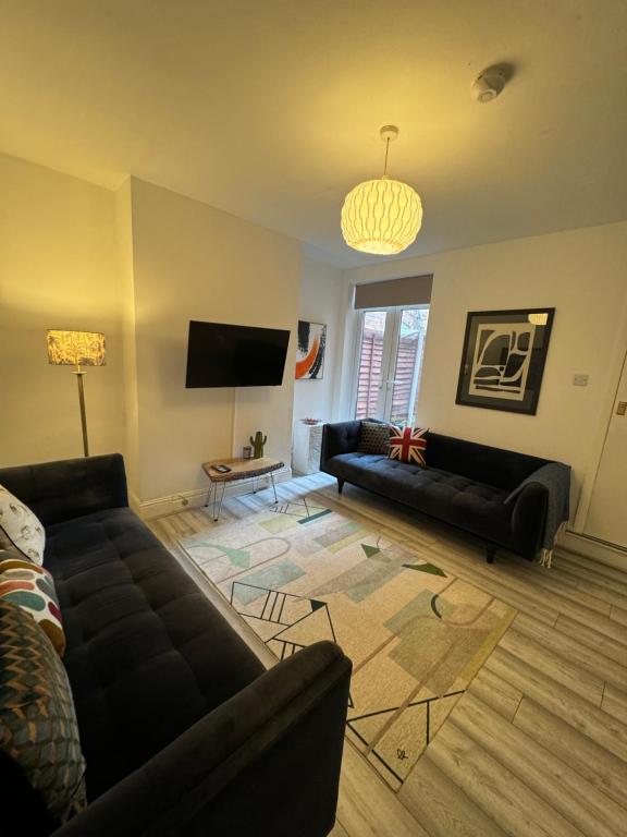 a living room with two couches and a flat screen tv at 3-Bed House, Birmingham in Birmingham