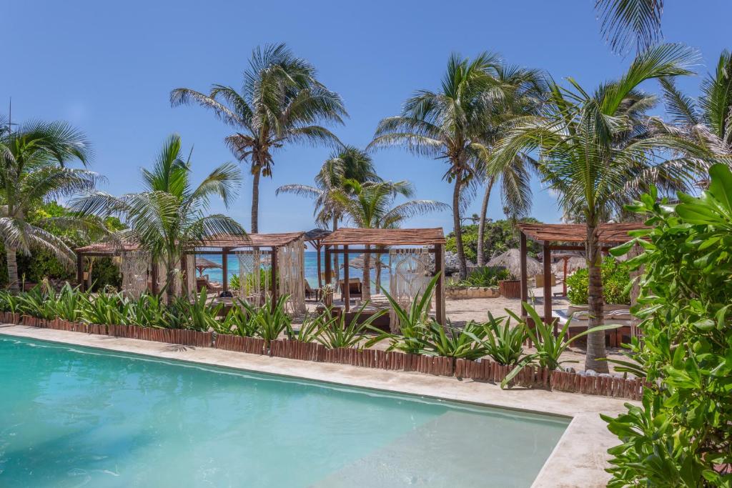 - une piscine avec des palmiers et un kiosque dans l'établissement Maria Del Mar Tulum - Adults Only, à Tulum