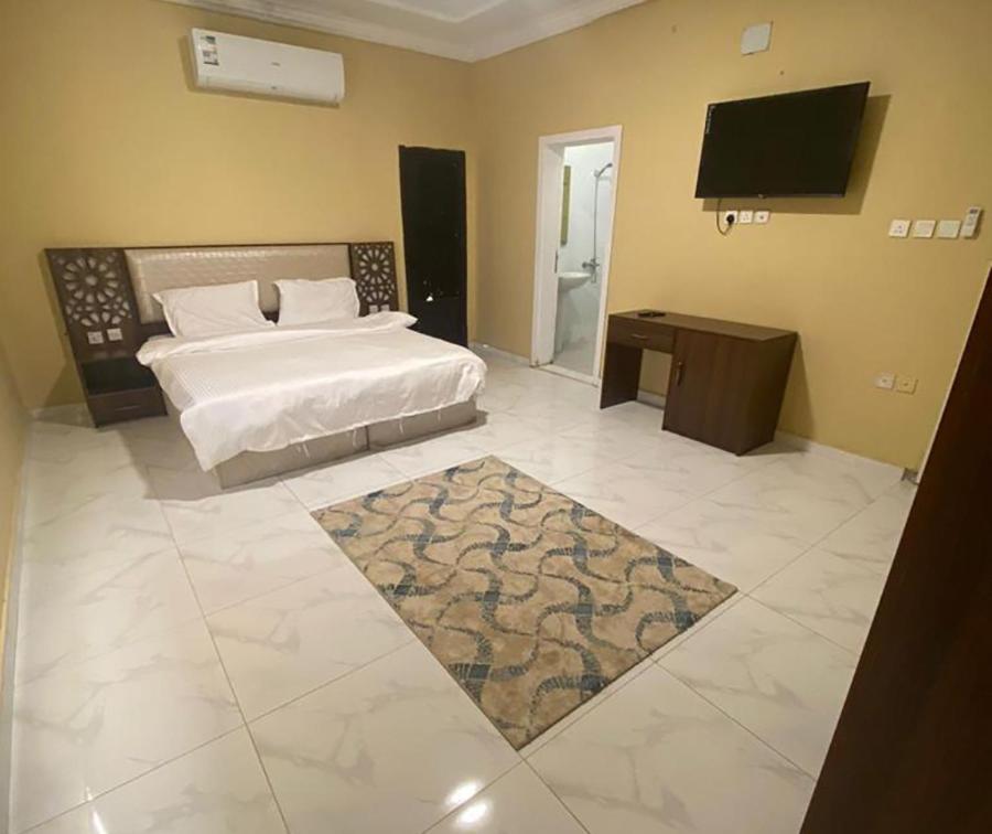 a bedroom with a bed and a flat screen tv at مسكن الجنان للوحدات السكنية in Al Madinah