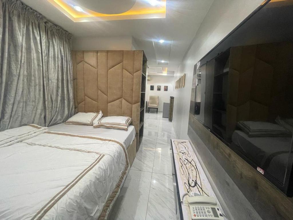 a bedroom with two beds and a flat screen tv at Ujuuu apartments in Lekki