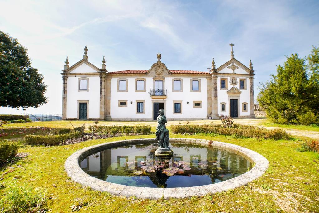 an estate with a fountain in front of a building at Solar das Bouças in Amares
