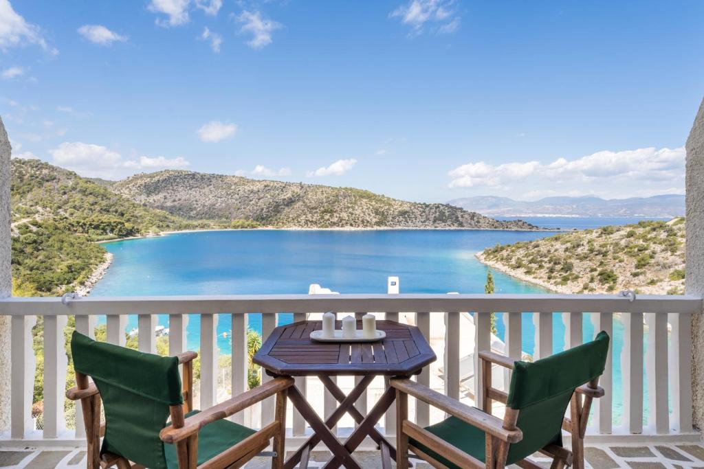 a table and chairs on a balcony with a view of the water at Villa Corali in Pefkali
