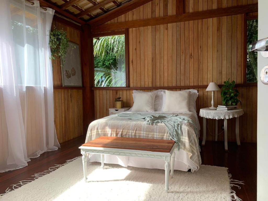 un dormitorio con una cama y una ventana en Glamping Casa D'Arvore Camburizinho, en São Sebastião