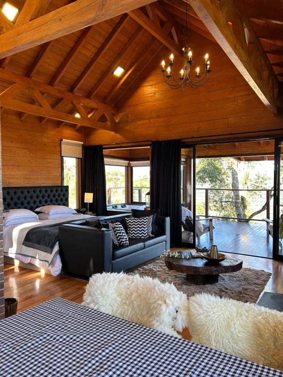 乌鲁比西Vallée Cabanas的一间卧室配有两张床、一张沙发和一个吊灯。