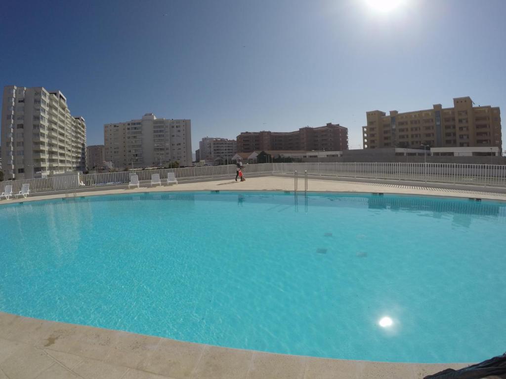 a large blue swimming pool with buildings in the background at DEPARTAMENTO EN LA SERENA A PASOS DE LA PLAYA in La Serena