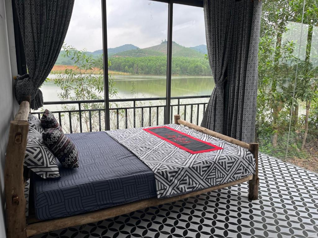 a bedroom with a bed with a view of a lake at Nguyen Shack - Phong Nha Resort in Phong Nha