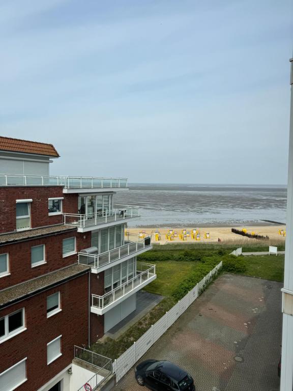a view of the beach from the balcony of a building at Traumhafte Ferienwohnung - direkter Meerblick - 50m zum Strand in Cuxhaven Duhnen in 1A Lage im Haus Seehütte in Cuxhaven