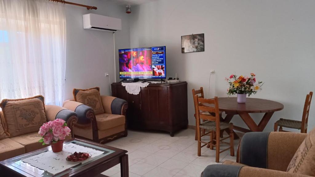 a living room with a couch and a tv at Green Haven Cottage in Delvinë