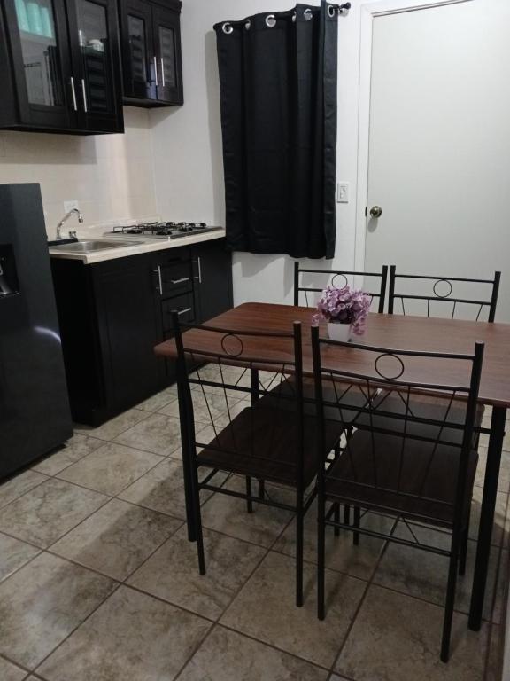 a kitchen with a wooden table and chairs and a kitchen with a sink at Estudios Manzanilla in Puerto Peñasco
