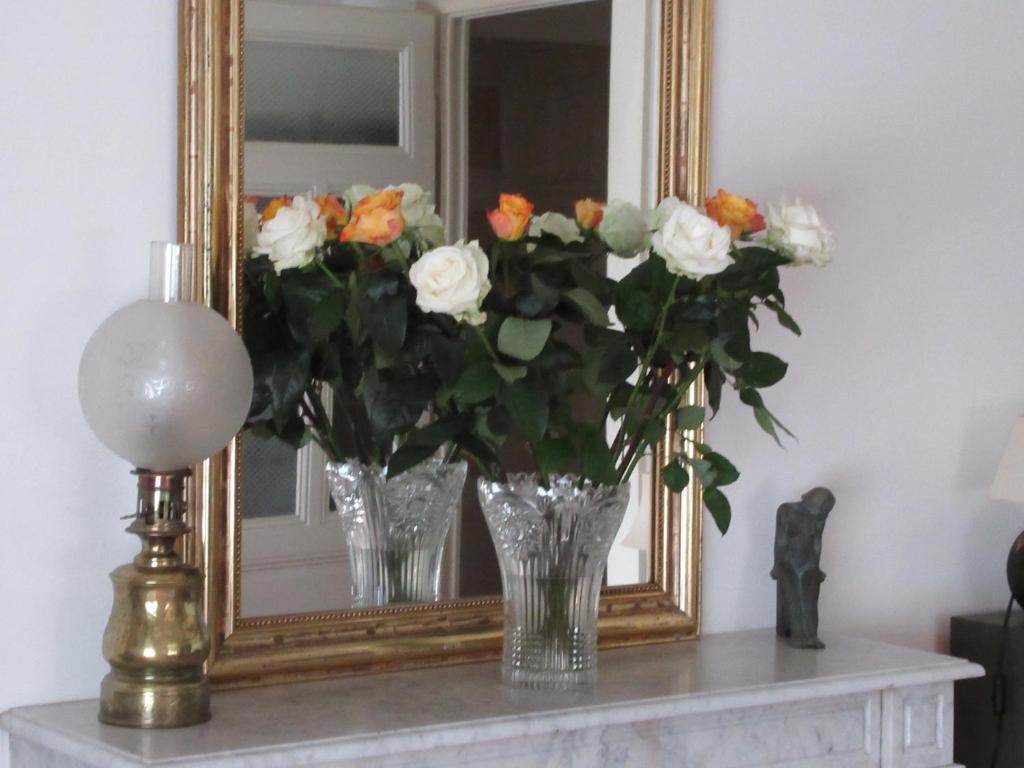 un vase de roses devant un miroir dans l'établissement Au premier, à Genève