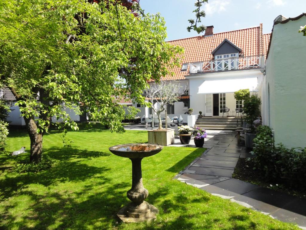 a garden with a birdbath in the yard of a house at Bed and Breakfast The Old Chestnut Tree Silkeborg in Silkeborg