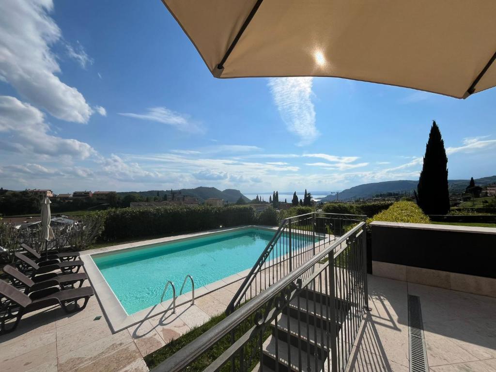 Blick auf den Pool vom Balkon eines Hauses in der Unterkunft Garda Moon Flats in Costermano sul Garda