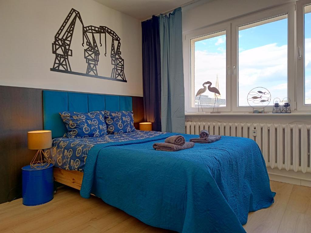 Un dormitorio con una cama azul con toallas. en Good Night in Szczecin en Szczecin