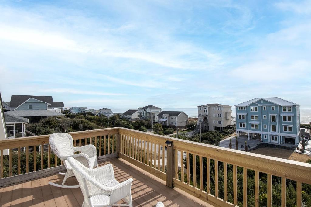 a balcony with two chairs and a view of the ocean at Azure home in Emerald Isle