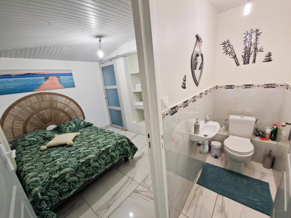 - une chambre avec un lit, des toilettes et un lavabo dans l'établissement Plézi Location F3 au bord de mer, Trois-Ilets, à Les Trois-Îlets