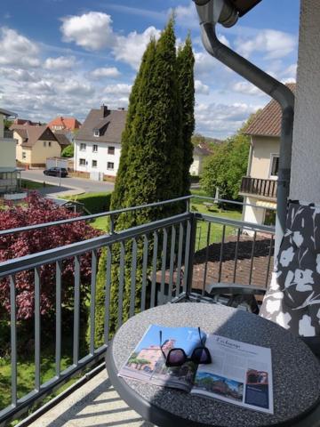 a table on a balcony with a book on it at Apartment Leuchtberg Flair Eschwege in Eschwege