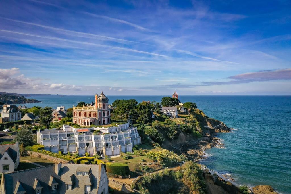 - une vue aérienne sur un bâtiment situé sur une falaise à côté de l'océan dans l'établissement Hotel Ker Moor Saint-Quay Portrieux, à Saint-Quay-Portrieux
