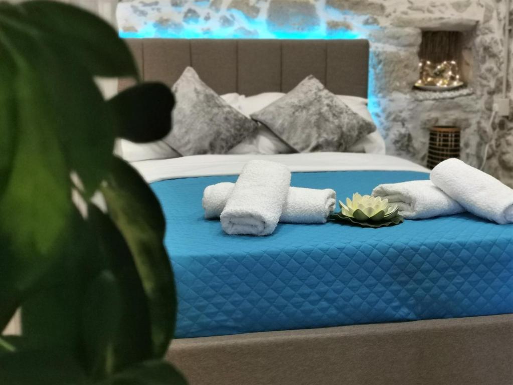 sypialnia z niebieskim łóżkiem i ręcznikami w obiekcie Cozy Stonehouse in Κissamos w mieście Kerá