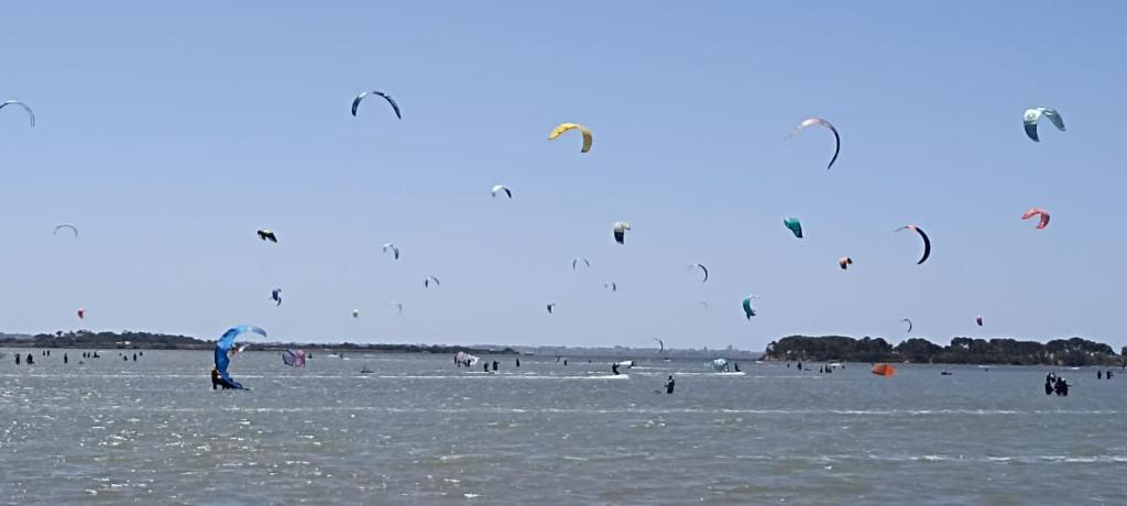 un gruppo di persone che volano aquiloni su una spiaggia di La casetta GioSa sullo Stagnone a Marsala