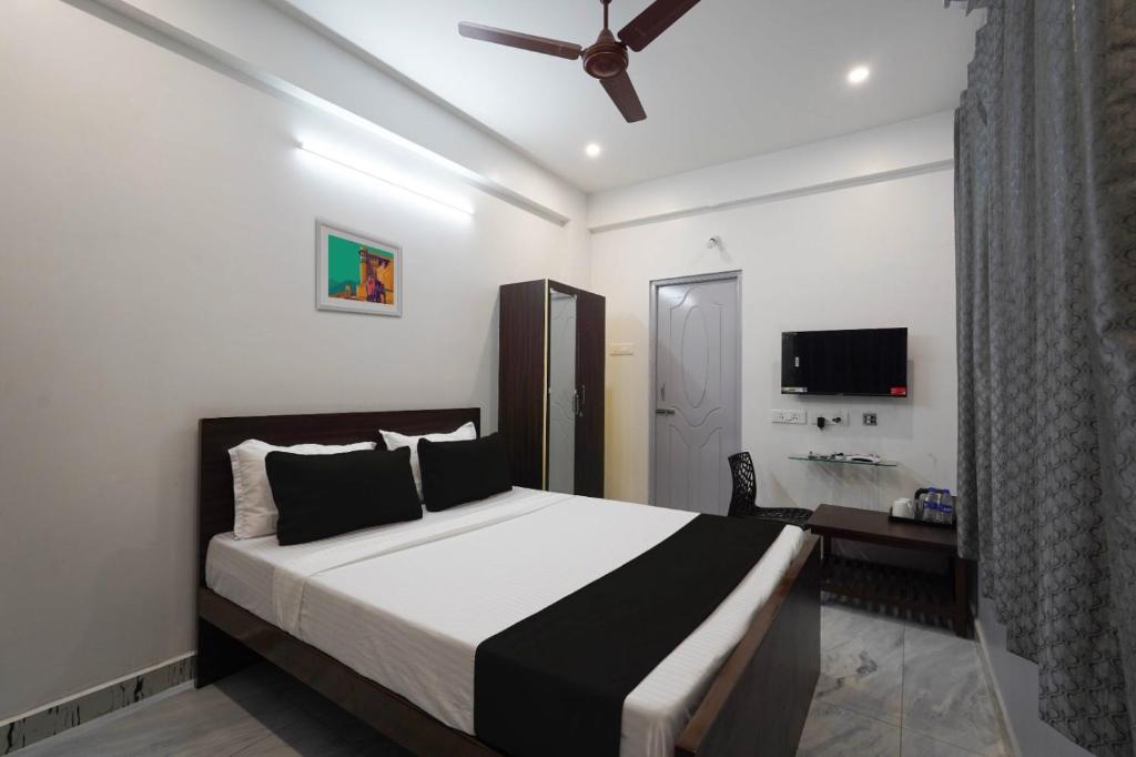 um quarto com uma cama grande e uma ventoinha de tecto em Hotel Stay inn Chennai Airport em Chennai