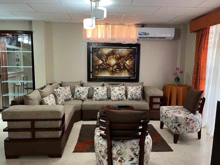 salon z dużą kanapą i krzesłami w obiekcie Elegante apartamento cerca del aeropuerto, Garzota w mieście Guayaquil