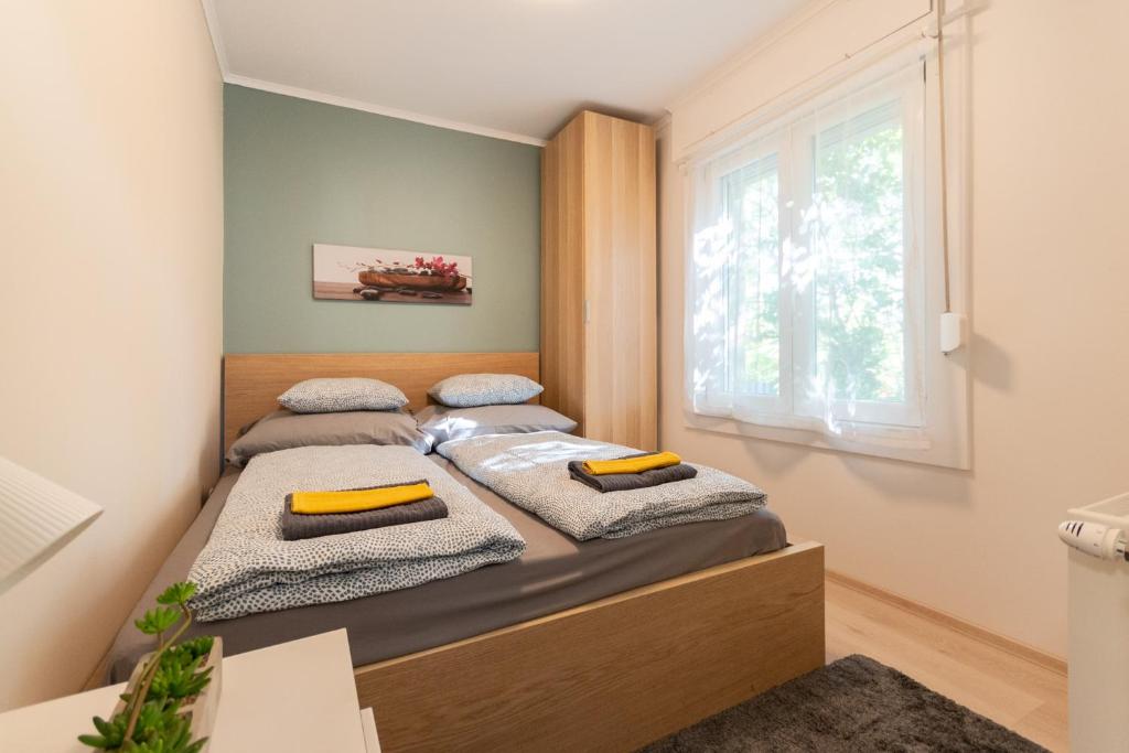2 Betten in einem kleinen Zimmer mit Fenster in der Unterkunft B12 Apartment Budapest in Budapest